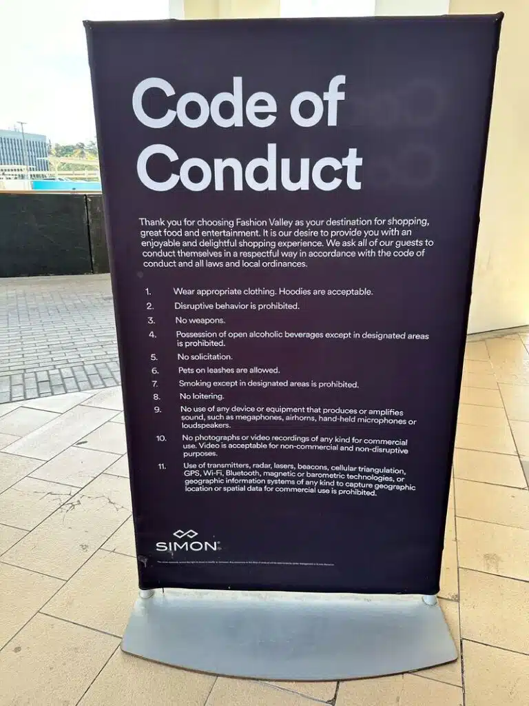 A code of Conduct sign for a shopping mall which details instructions for behaviour. One of the rules is 'No weapons.'