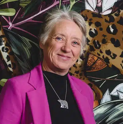 Ann Daniels headshot motivational speaker smiling wearing a pink blazer