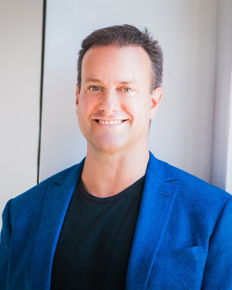 Greg Wells, leadership speaker in blue jacket